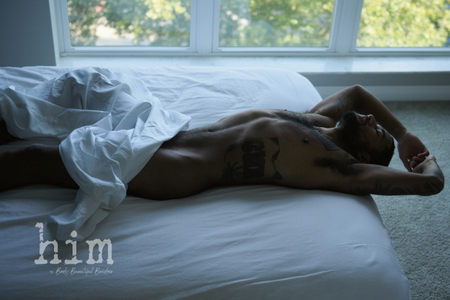 Nude tattooed male in the sheets