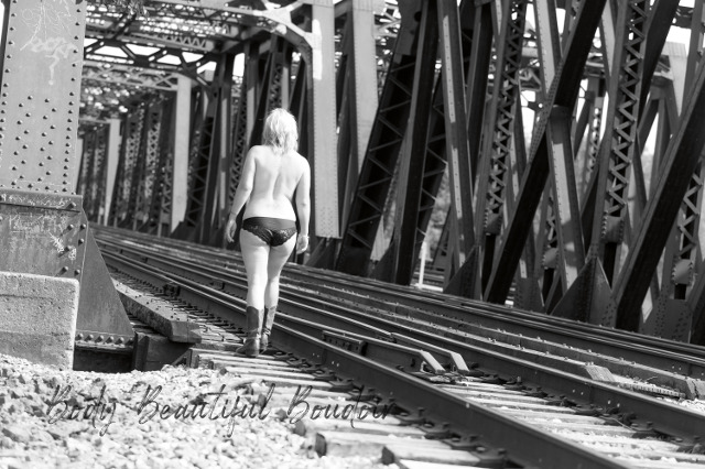 Topless blonde on railroad track